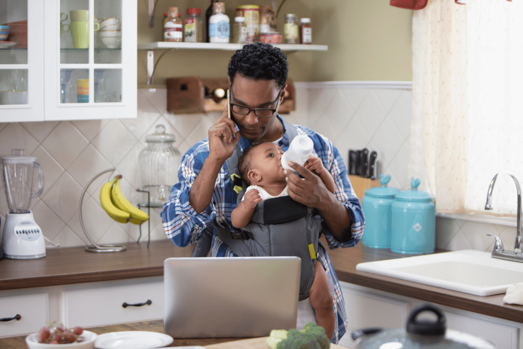 working parent on the phone holding baby