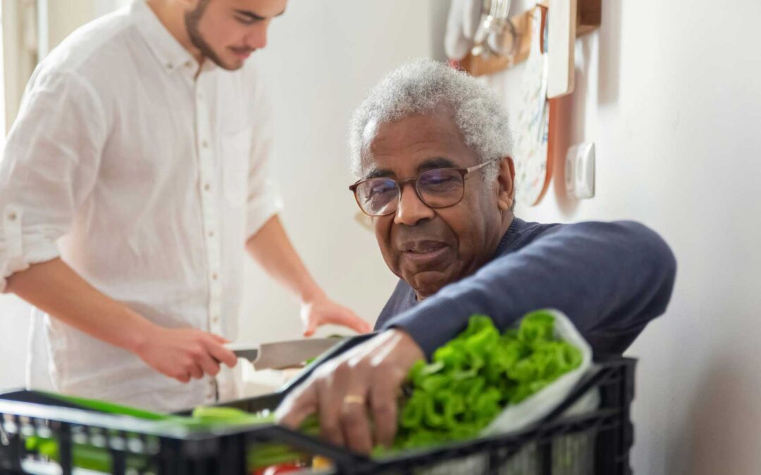 Bastrop county cares change agents. Older man and young man unloading vegetables from crate