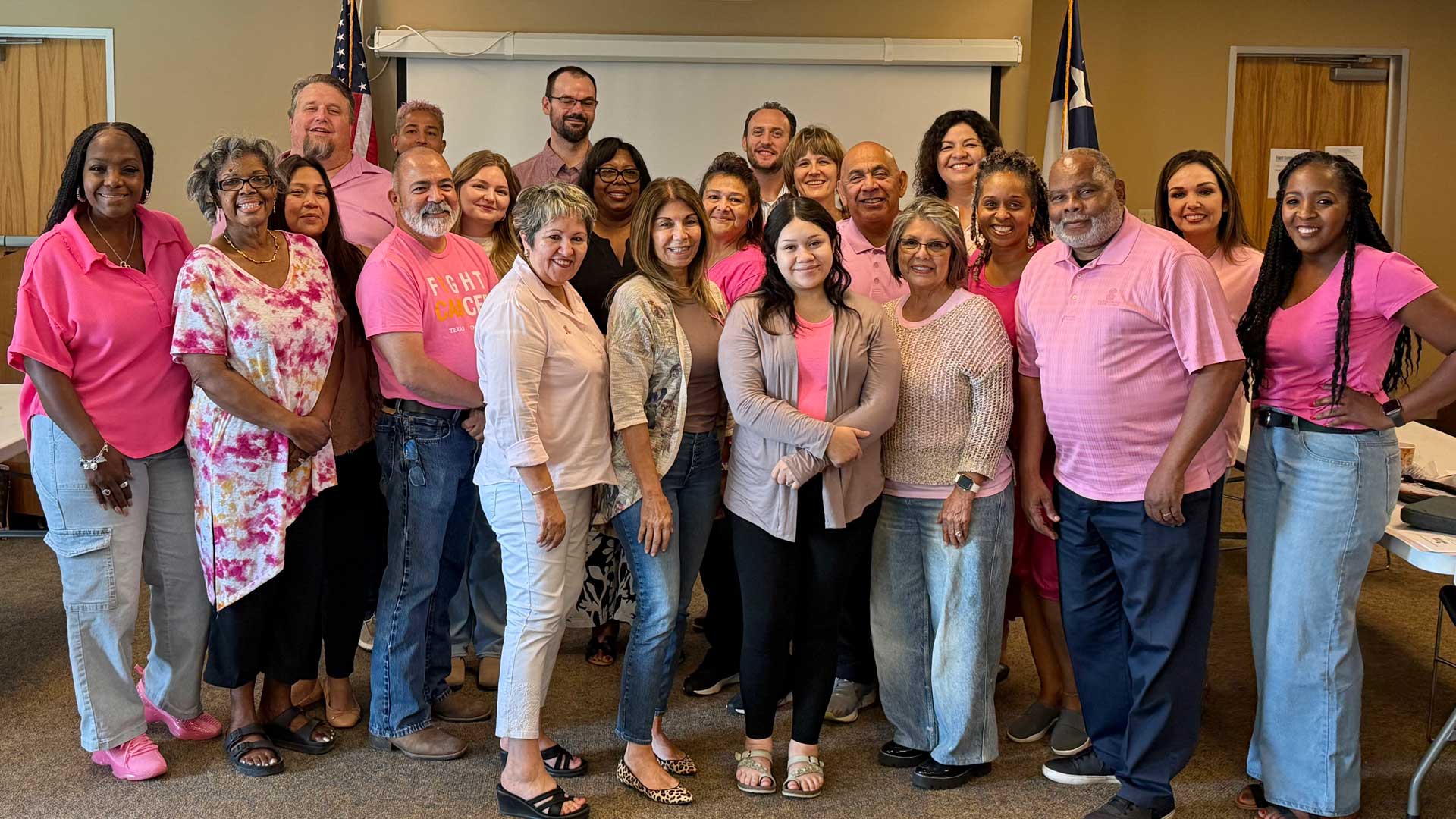 Grupo del equipo Bastrop County Cares vestido de rosa