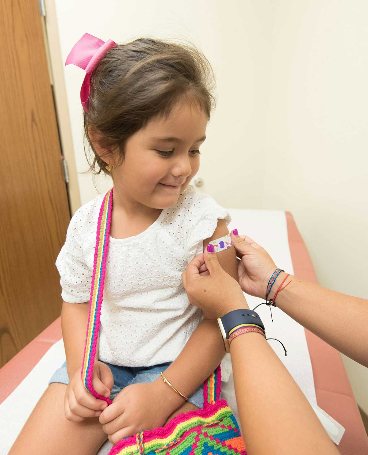 Niña en la consulta del médico recibiendo una tirita