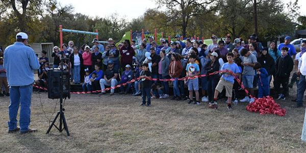 Bastrop-County-Cares-Our-History-600x300 Group of people seated at Bastrop County Cares Event listening to speaker