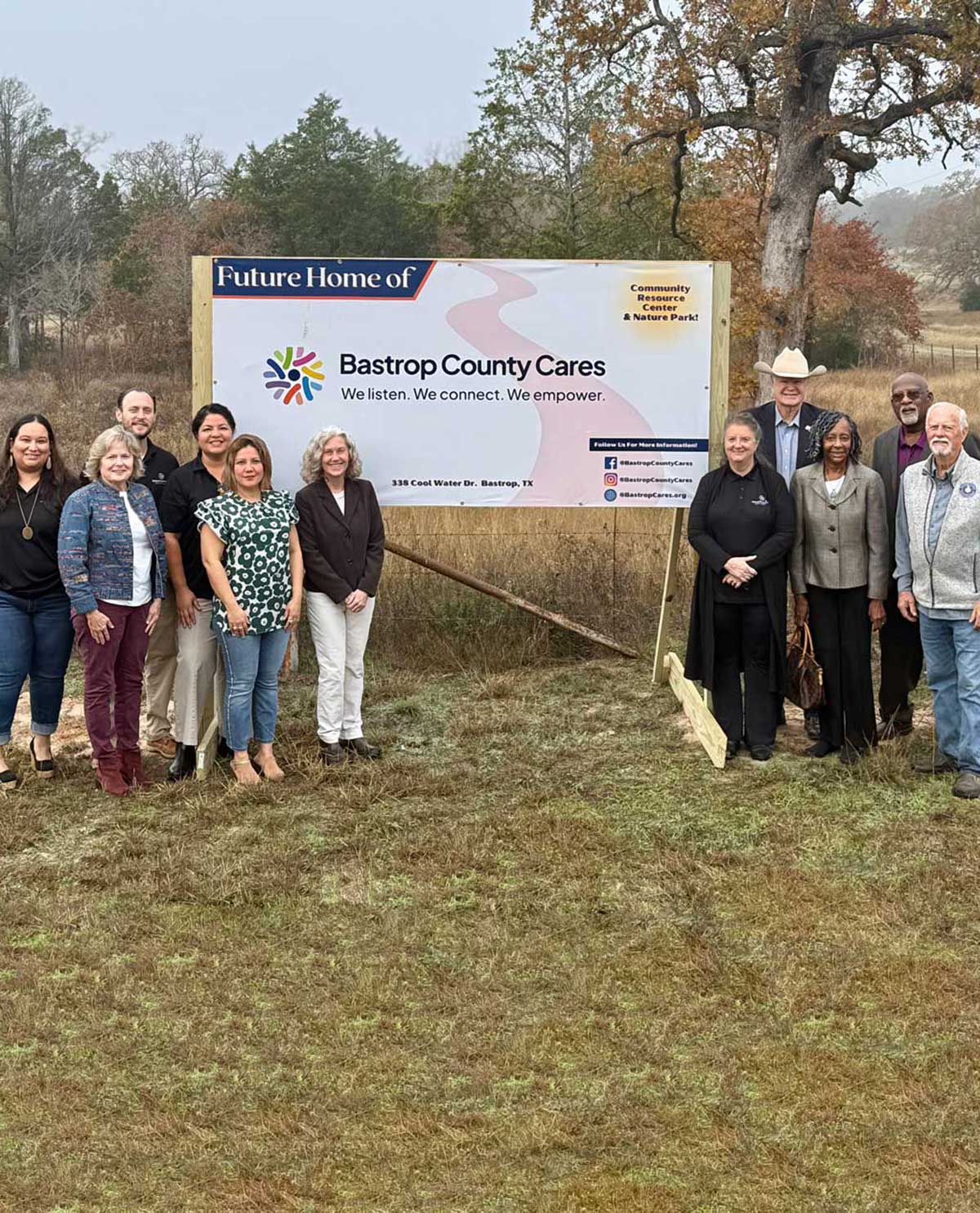 Bastrop County Cares Team in front of "Future site of BCC" sign