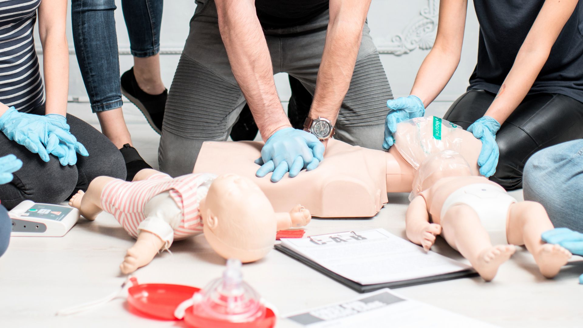 Instructor demonstrating CPR techniques on a toddler training mannequin during a Baby & Toddler CPR Class