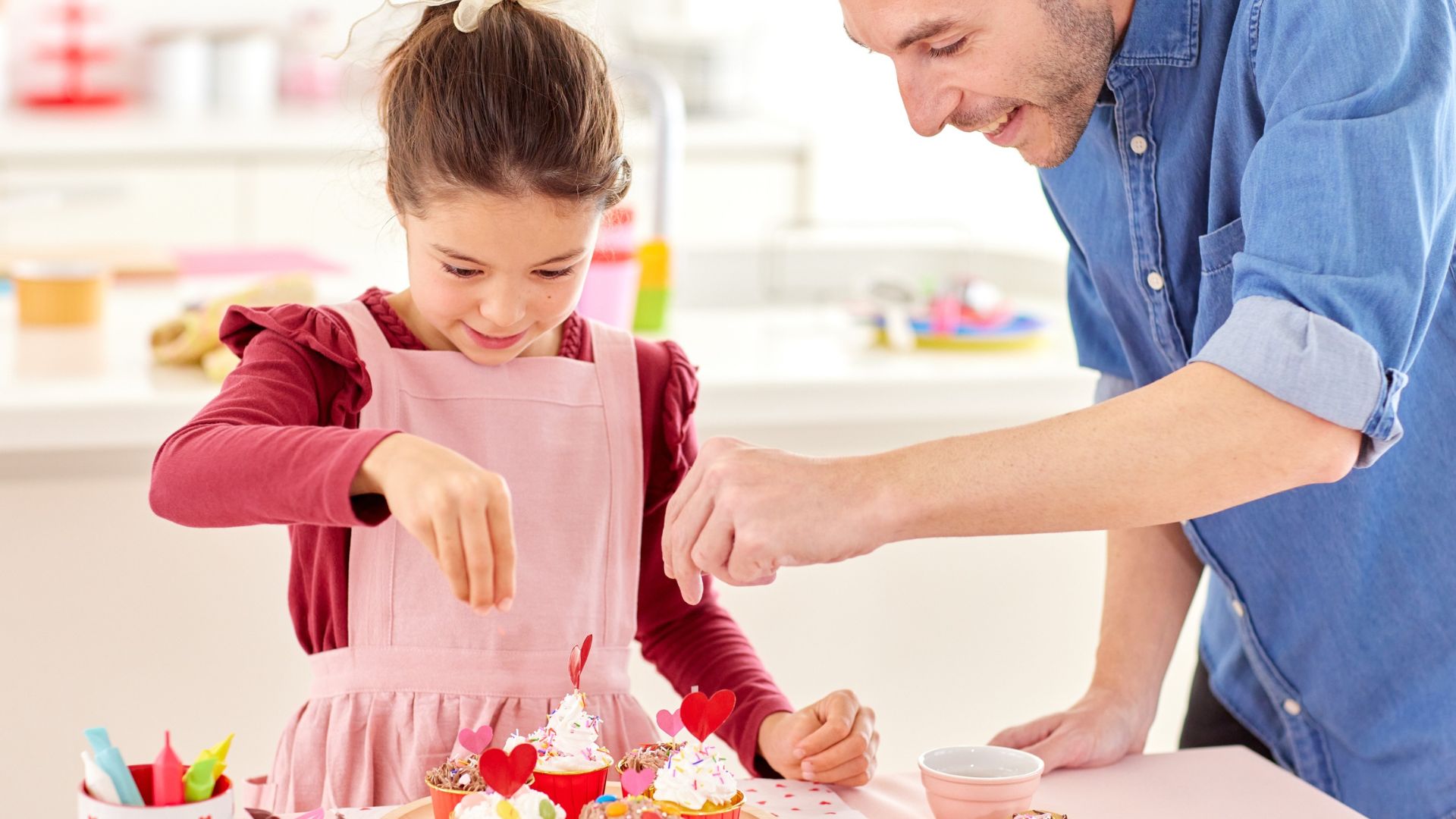 Dad and daughter decorating cupcakes