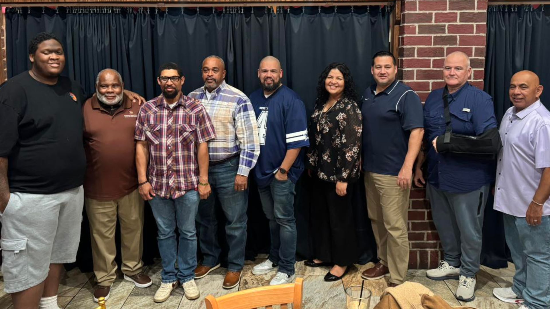 Group photo of participants and facilitators from the 24/7 Fatherhood Class standing together during a weekly fatherhood support and parenting program hosted by Bastrop County Cares.