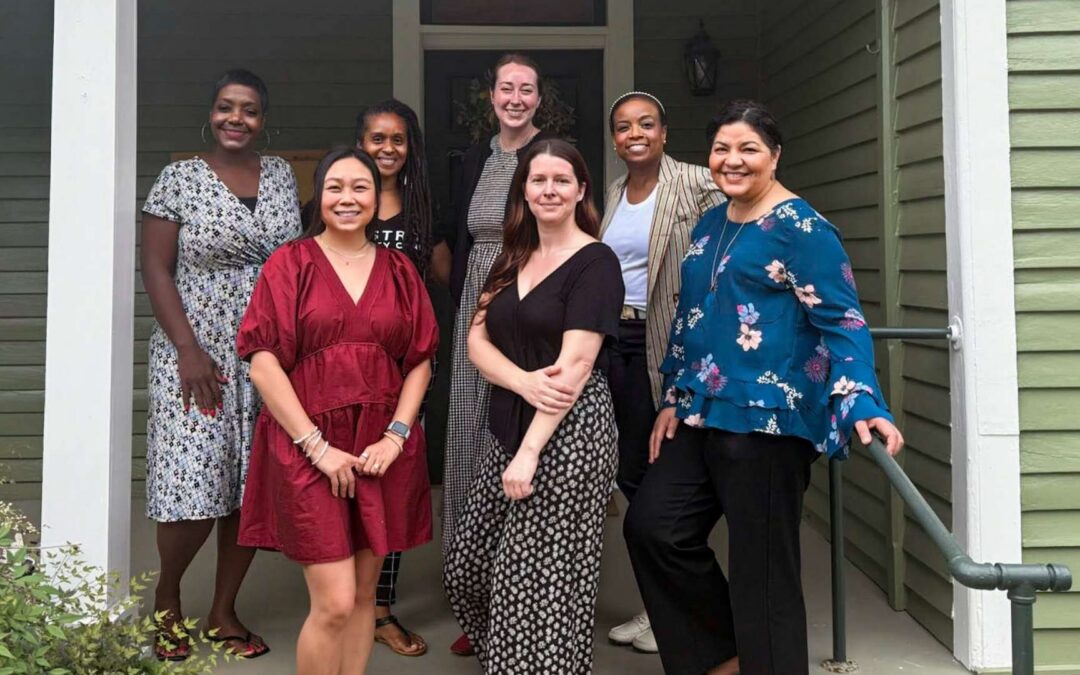 A group of community leaders and maternal health partners standing together outside the Bastrop Birthing Center as part of the W.O.M.B. 360 Collaborative supporting maternal health in Bastrop County.