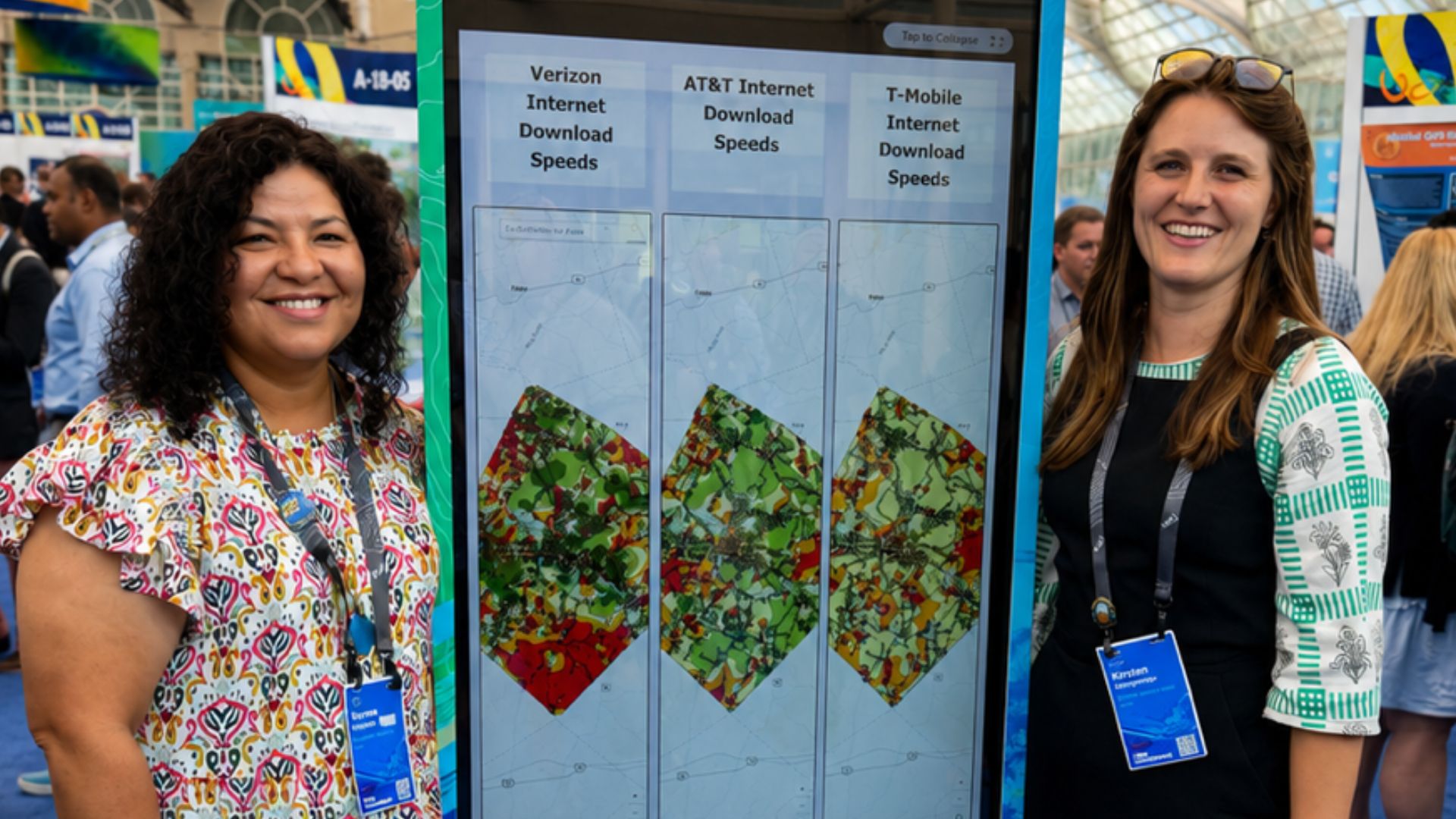 Los miembros del equipo de Bastrop County Cares posan junto a su pantalla de mapas SIG en la Galería de Mapas Interactivos de la Conferencia de Usuarios de Esri.