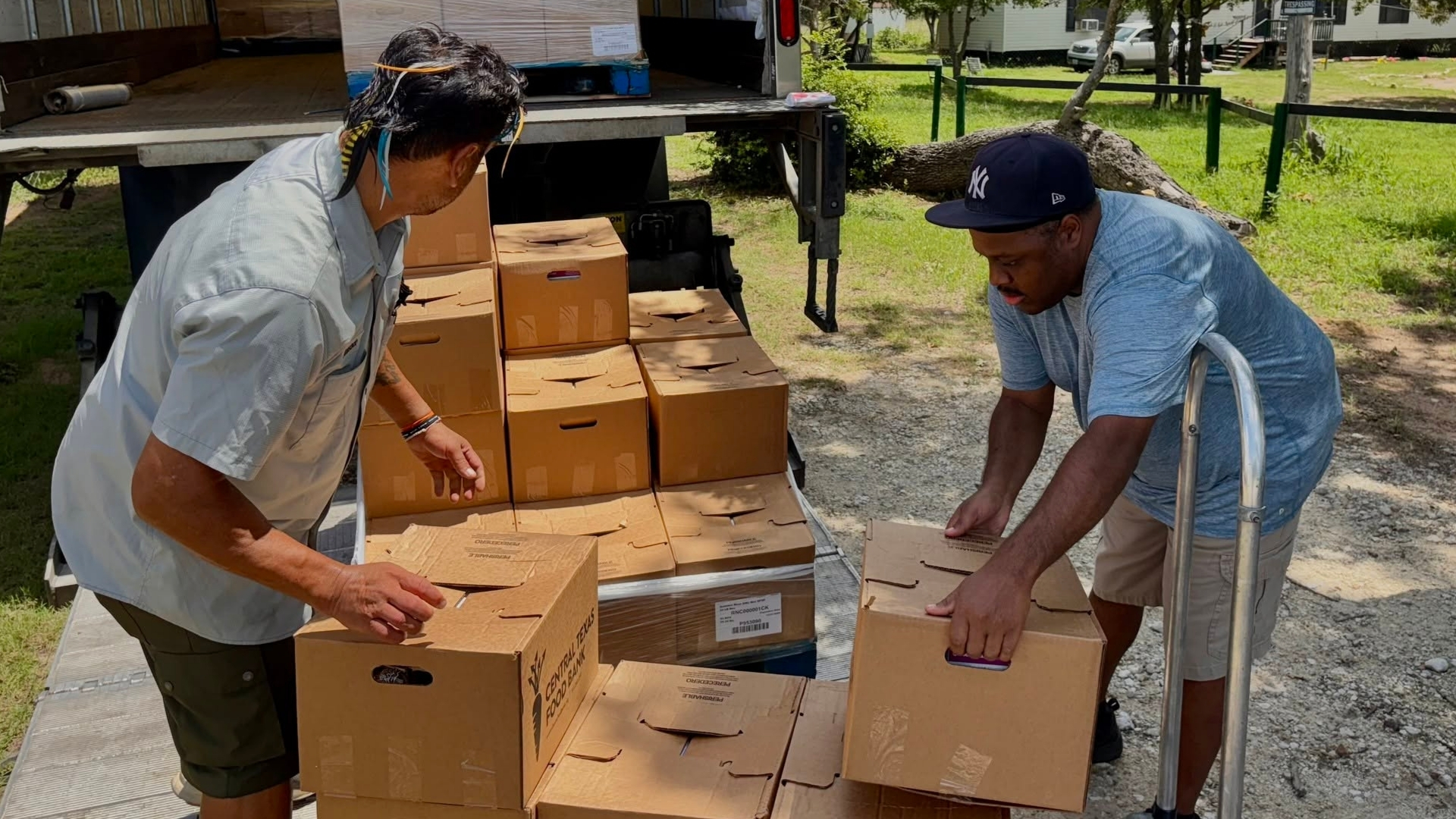 Summer Meal Program Food Distribution in Bastrop County Two community partners unload boxes of food from a truck for a summer meal distribution in Bastrop County.